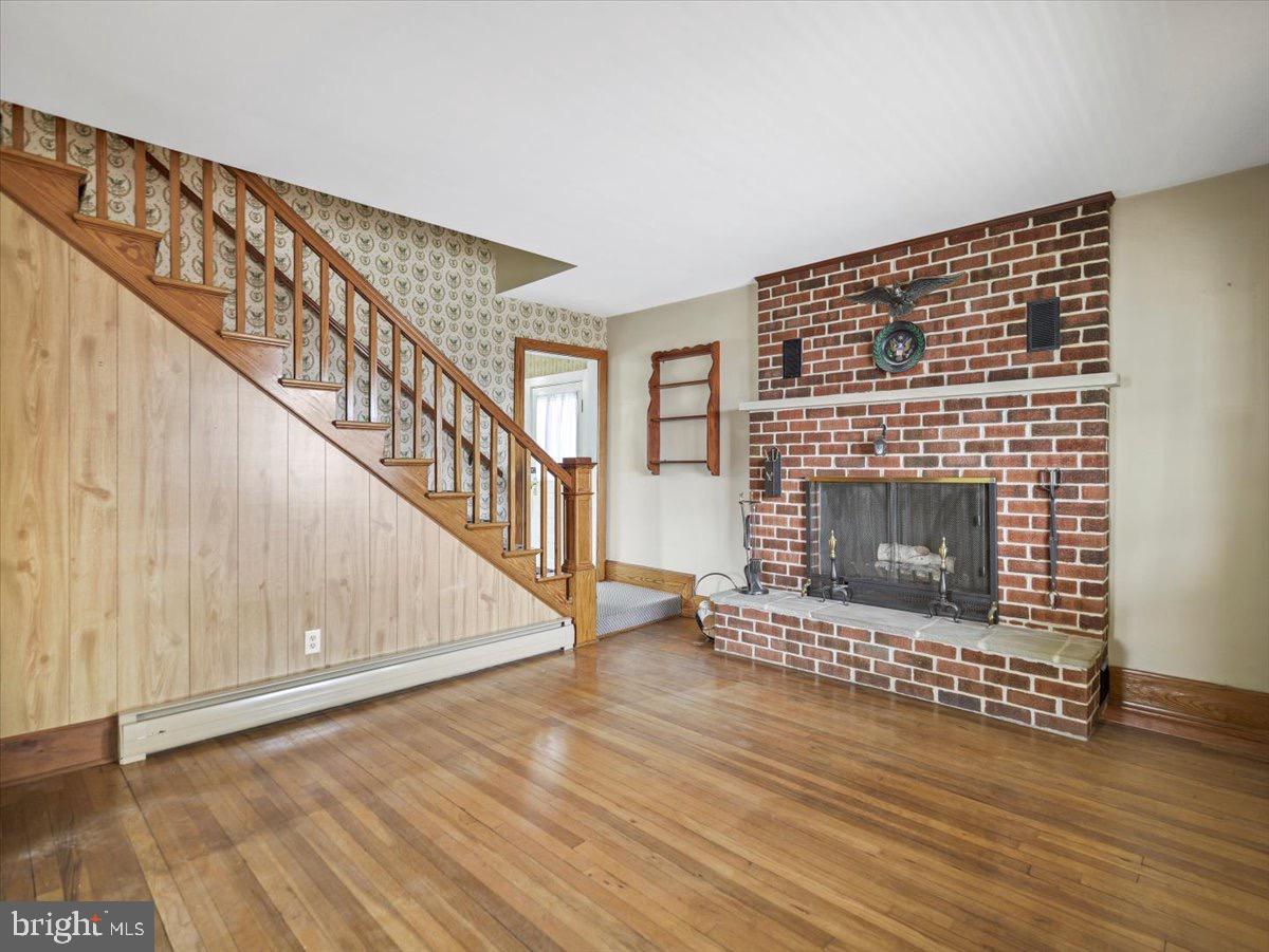 7220 Slabtown Road Waynesboro, PA 17268 - Photo 6 of 43 a living room with wooden floor and a fireplace