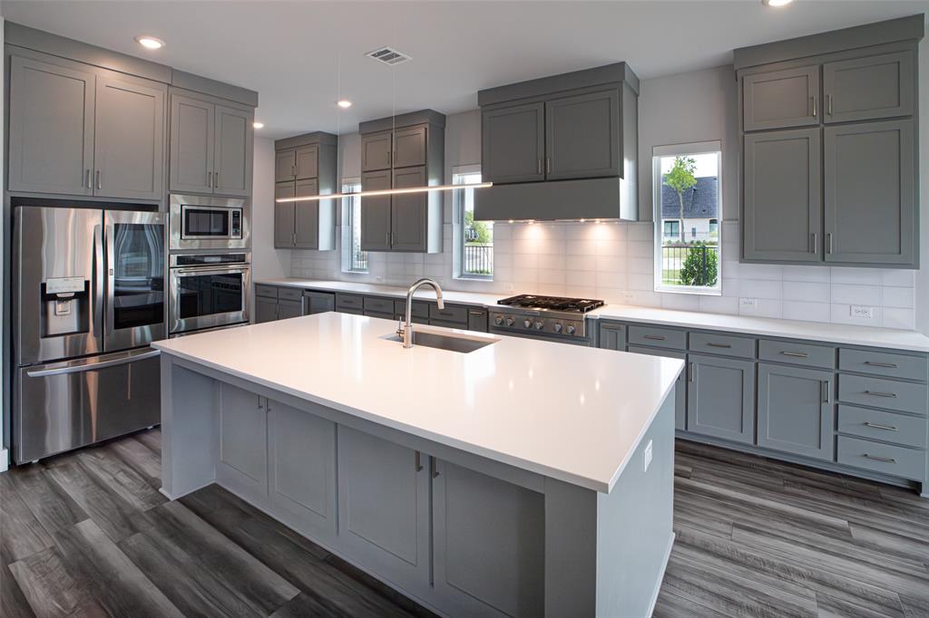 8003 Splitbeard Road Frisco, TX 75035 - Photo 11 of 40 a kitchen with kitchen island granite countertop a sink and counter space