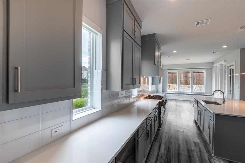 8003 Splitbeard Road Frisco, TX 75035 - Photo 15 of 40 a kitchen with counter top space a sink and appliances