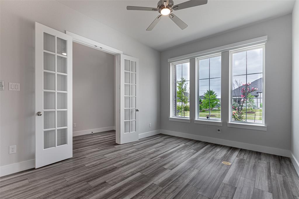 8003 Splitbeard Road Frisco, TX 75035 - Photo 18 of 40 an empty room with wooden floor fan and windows