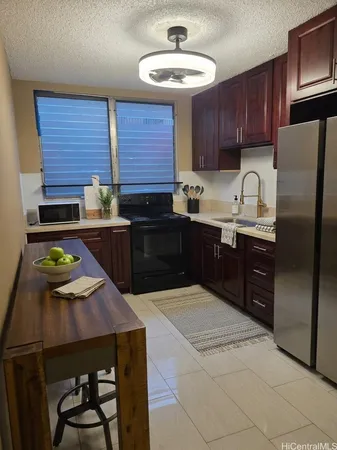 a kitchen with stainless steel appliances granite countertop wooden cabinets a stove a sink and a refrigerator