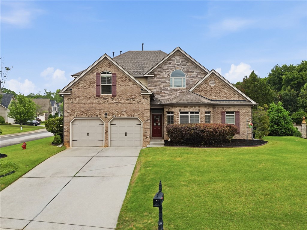 This residence showcases a blend of brick and stone, complemented by an inviting front entrance.