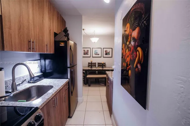a kitchen with stainless steel appliances granite countertop a refrigerator and a sink