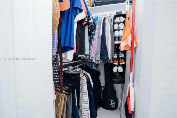 a view of walk in closet with clothes and shoes
