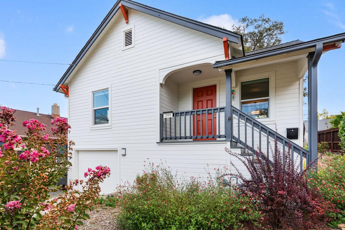 a view of a house with large windows and flower plants