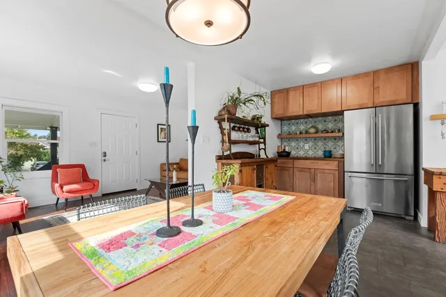 a kitchen with stainless steel appliances refrigerator dining table and chairs