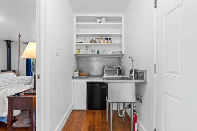 a kitchen with a sink cabinets and wooden floor