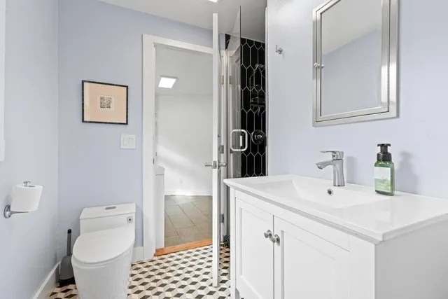 a bathroom with a sink a toilet and shower