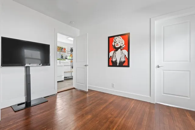 a view of a livingroom with wooden floor and a flat screen tv