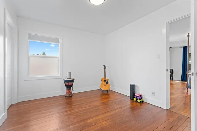 a view of a room with wooden floor and painting on the wall