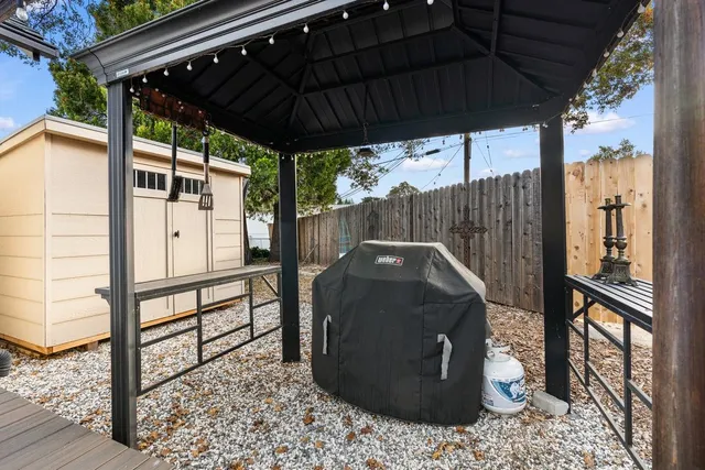 a view of a backyard with plants and furniture