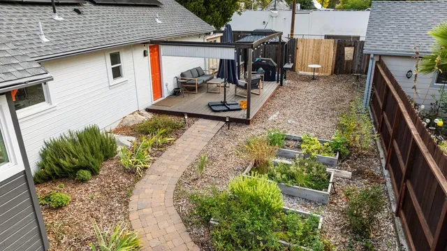 a backyard of a house with large trees and wooden fence