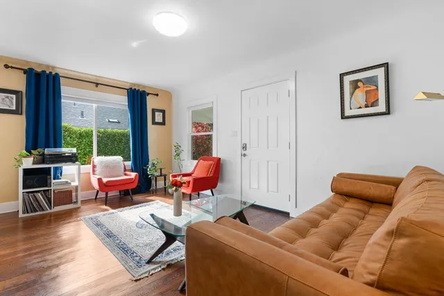 a living room with furniture a rug and a floor to ceiling window