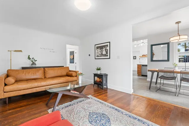 a living room with furniture a rug and a table