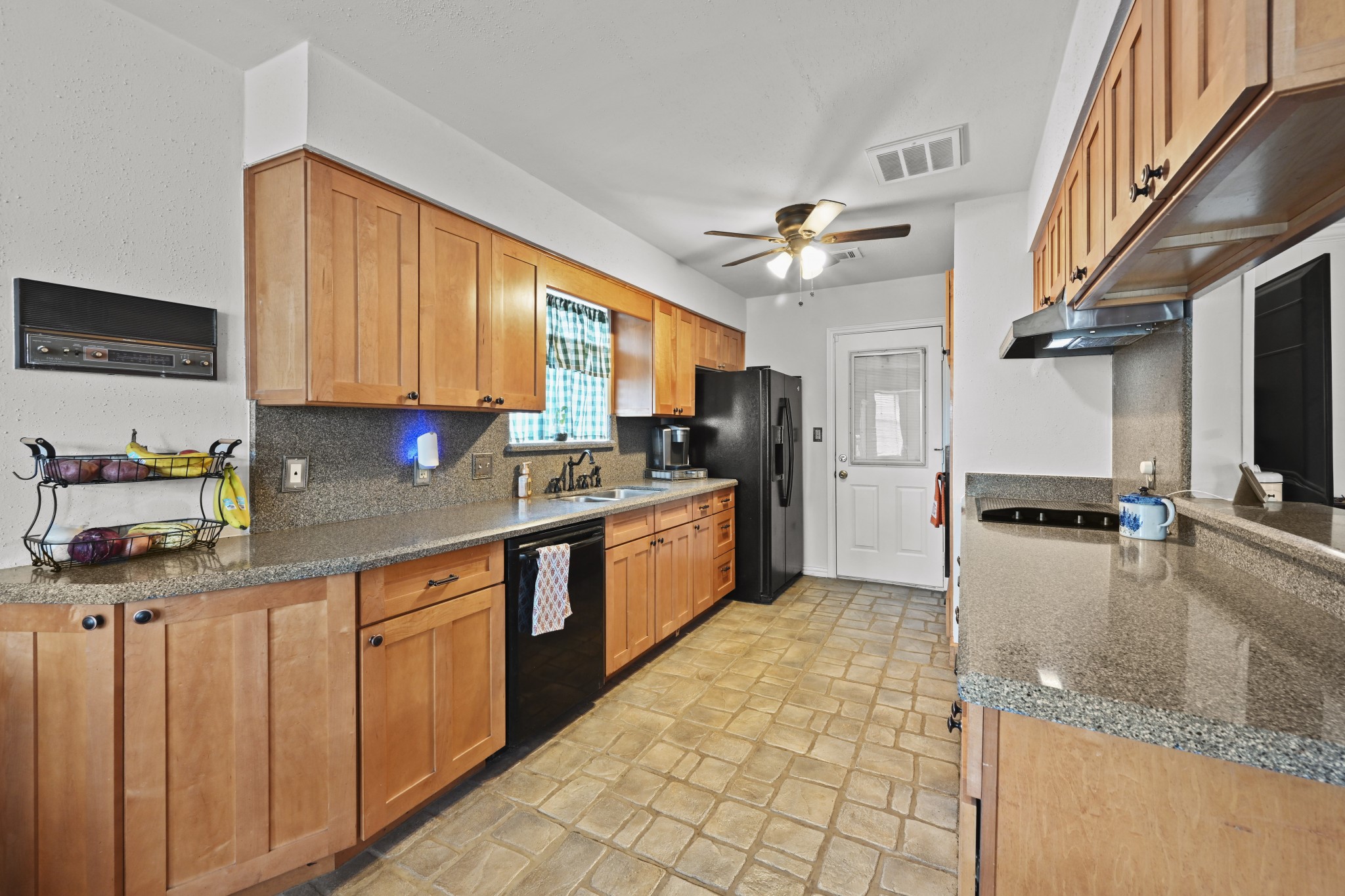 13823 Wickersham Lane Houston, TX 77077 - Photo 11 of 24 a kitchen with stainless steel appliances granite countertop a sink a stove top oven a chimney cabinets and a counter top space
