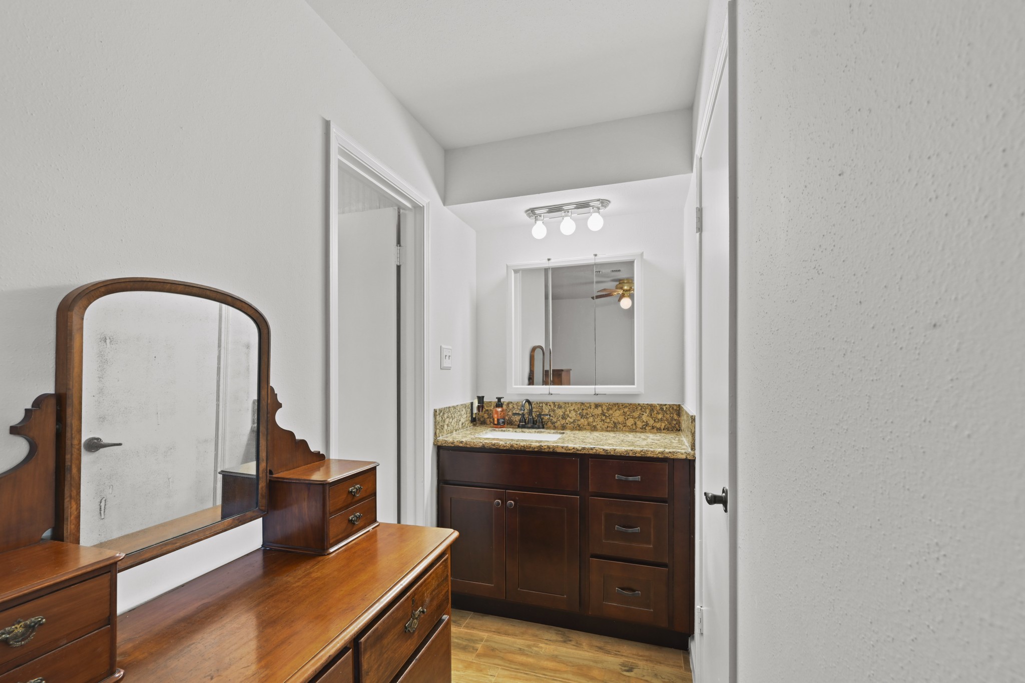 13823 Wickersham Lane Houston, TX 77077 - Photo 18 of 24 a en suite bathroom with a granite countertop sink and a mirror