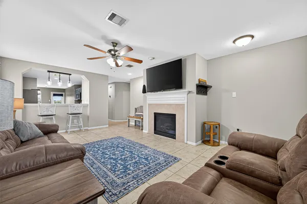 a living room with furniture a fireplace and a flat screen tv