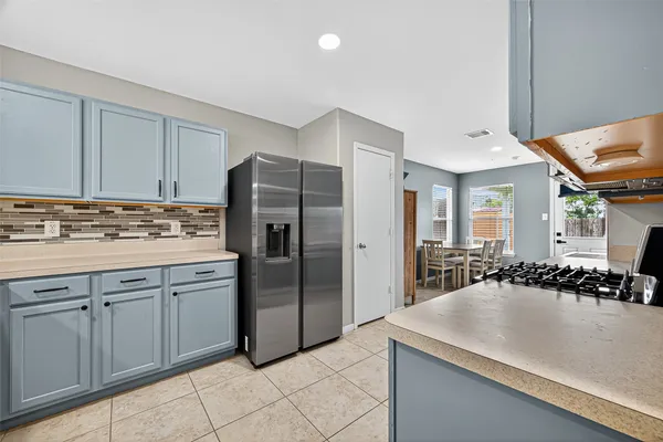 a kitchen with a sink a refrigerator and cabinets