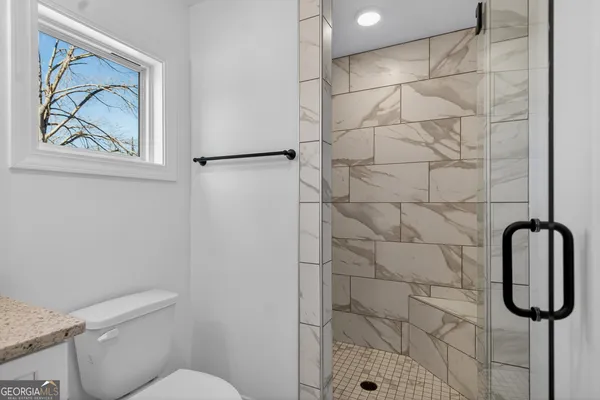 a bathroom with a toilet and a shower