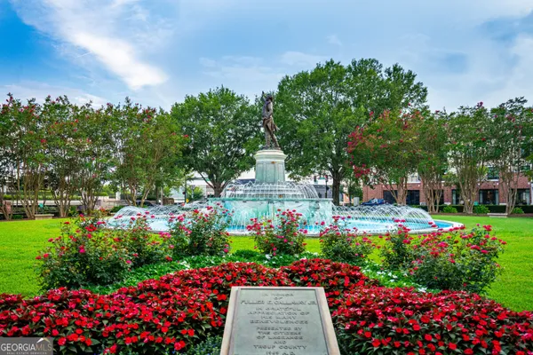 a view of a garden with flowers and trees