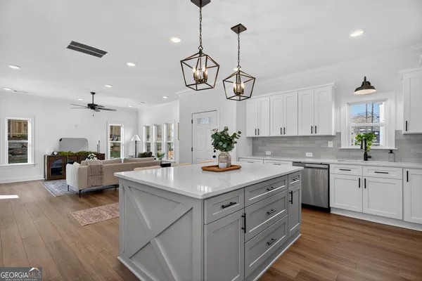a kitchen with white cabinets and chandelier