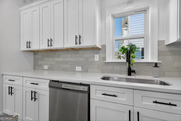 a kitchen with stainless steel appliances white cabinets and a sink
