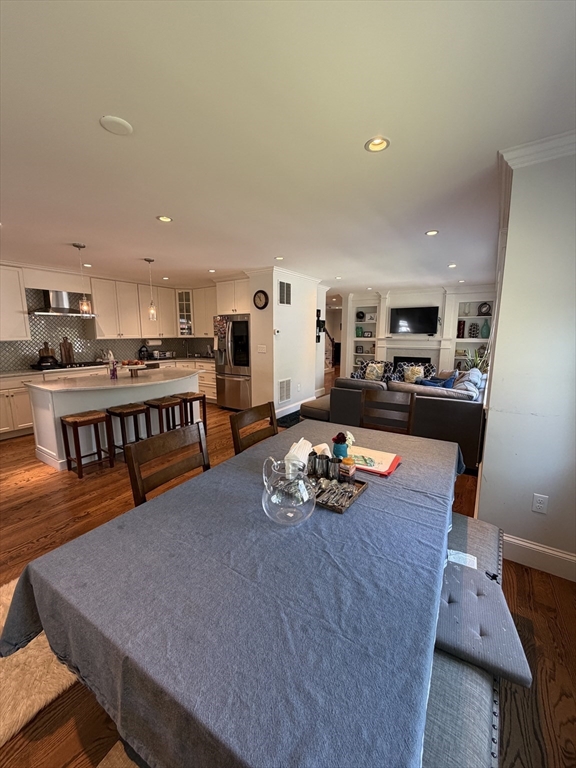 17 Cardinal Street, Unit 17 Winchester, MA 01890 - Photo 8 of 42 a kitchen with stainless steel appliances granite countertop a stove a refrigerator a sink a dining table and chairs with wooden floor