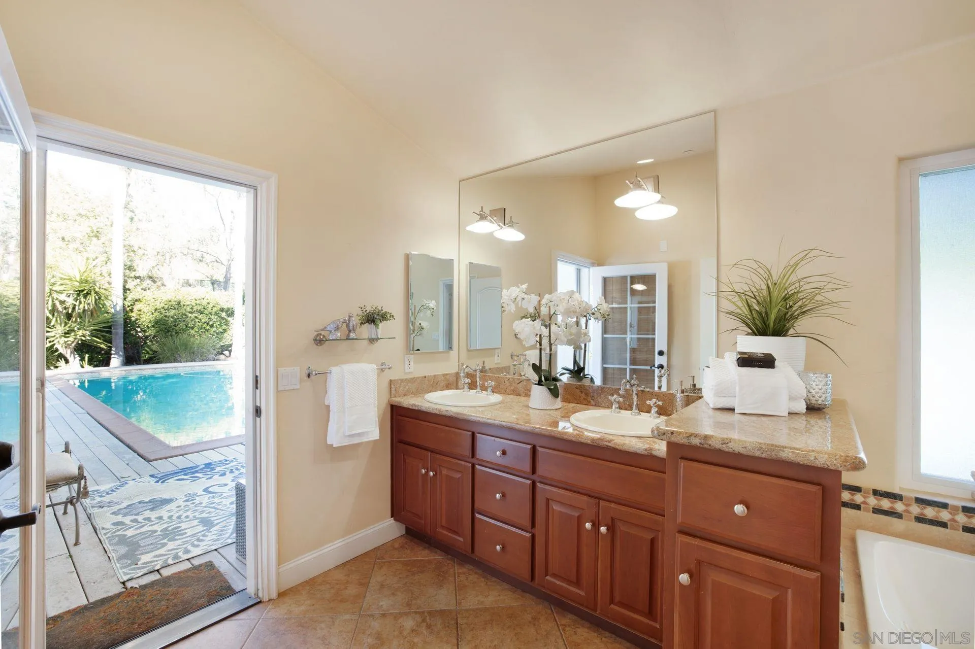 7671 La Brisa Rancho Santa Fe, CA 92067 - Photo 13 of 34 a spacious bathroom with a granite countertop sink mirror and a bathtub