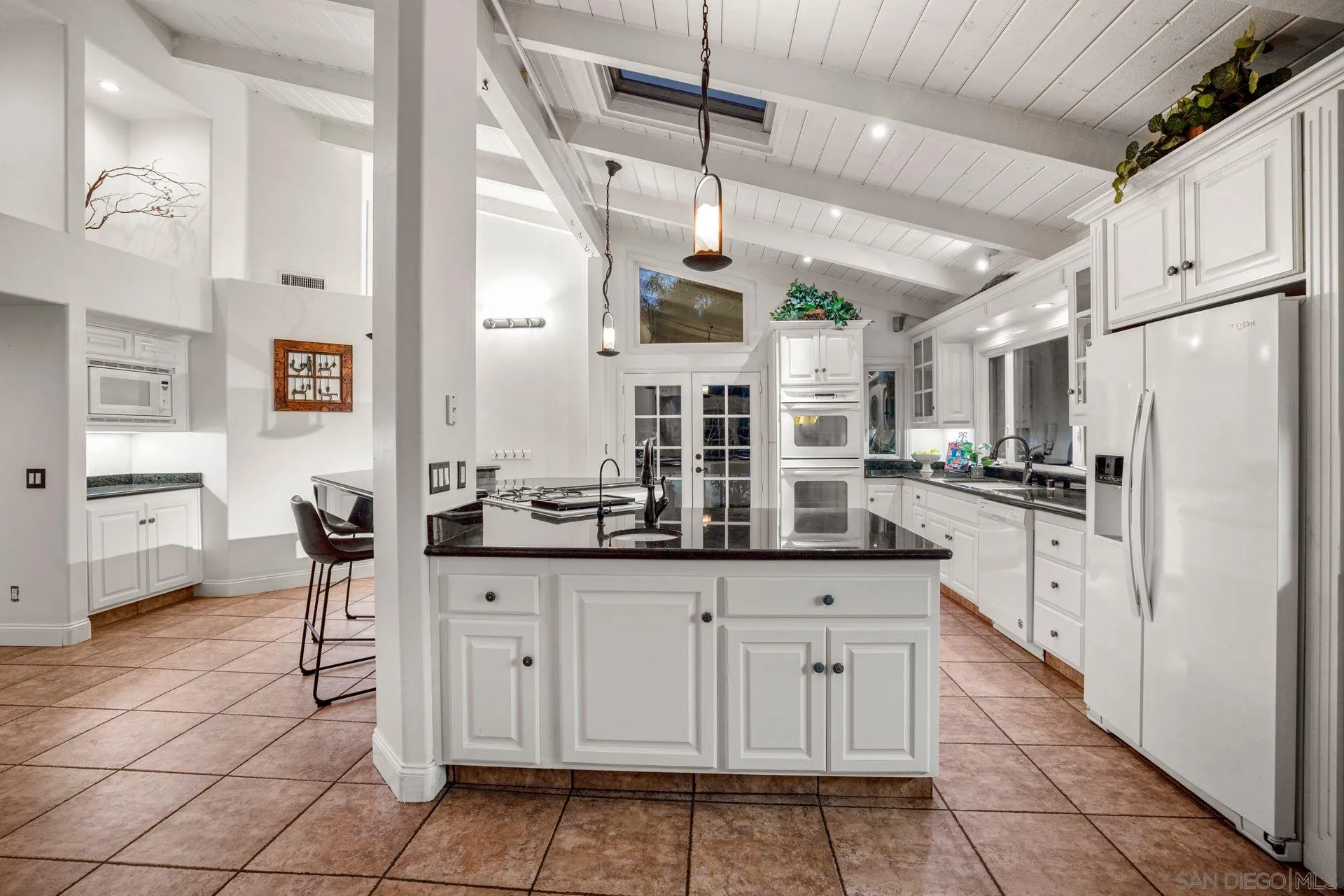 7671 La Brisa Rancho Santa Fe, CA 92067 - Photo 22 of 34 a kitchen with granite countertop white cabinets and white appliances
