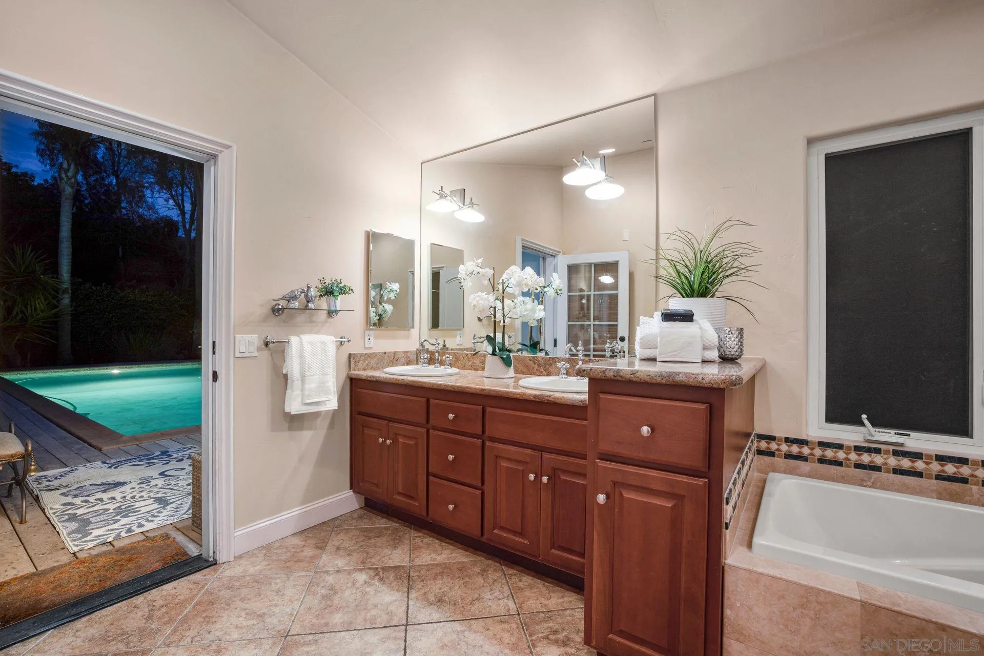 7671 La Brisa Rancho Santa Fe, CA 92067 - Photo 25 of 34 a bathroom with a granite countertop tub a double vanity sink a mirror and next to a window