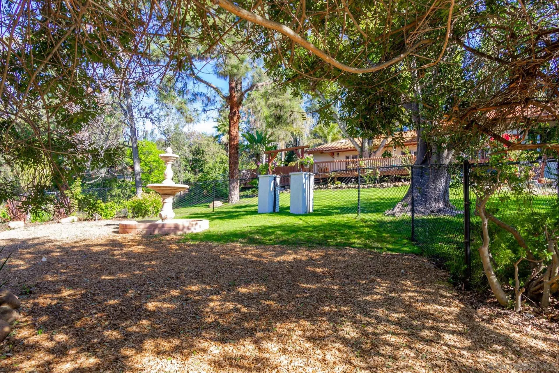 7671 La Brisa Rancho Santa Fe, CA 92067 - Photo 26 of 34 a front view of a house with a yard and a garden