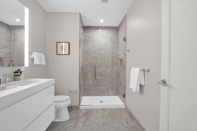 a bathroom with a double vanity sink toilet and shower