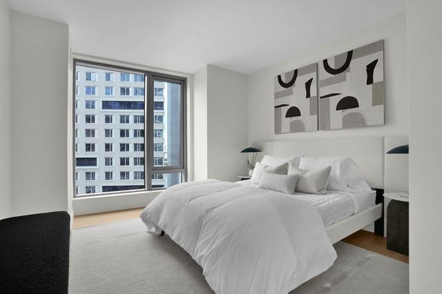 a bedroom with a large bed and a window