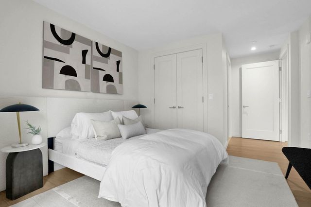 a bedroom with a large bed and a painting on the wall