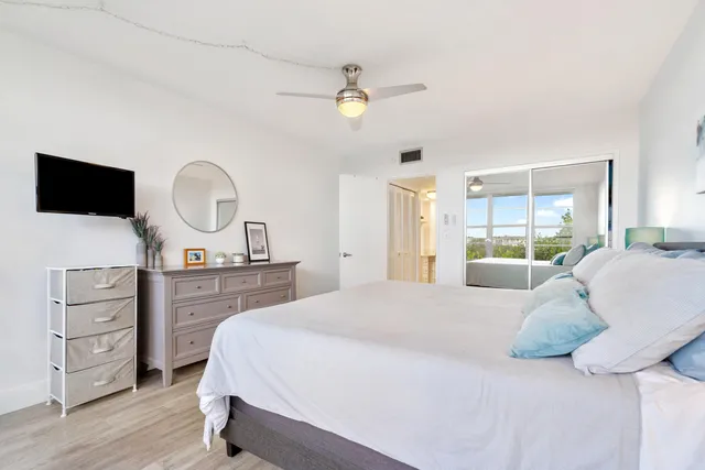 a spacious bedroom with a large bed and a chandelier