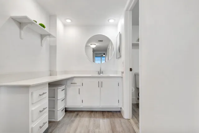 a spacious bathroom with a granite countertop toilet a sink and a mirror