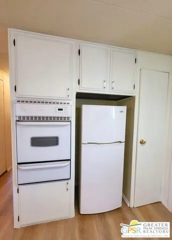 a white refrigerator freezer and a stove sitting inside of a kitchen