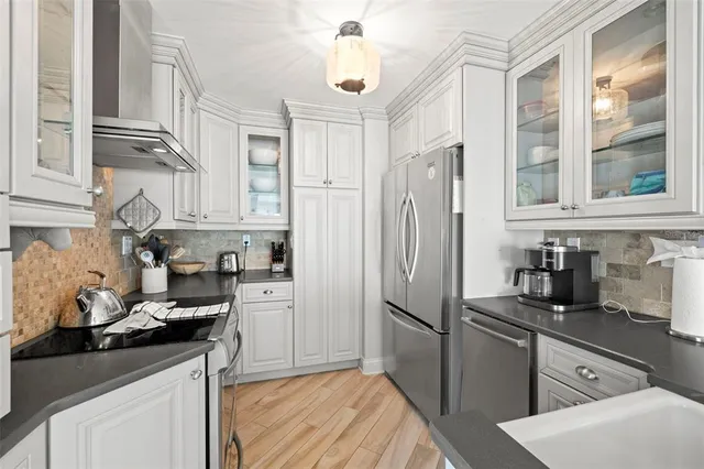 a kitchen with stainless steel appliances granite countertop a refrigerator sink and stove