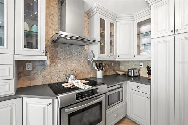 a kitchen with stainless steel appliances granite countertop white cabinets and white appliances