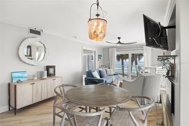a dining room with wooden floor a chandelier a wooden table and chairs