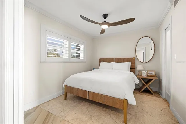 a bedroom with a bed mirror and a window