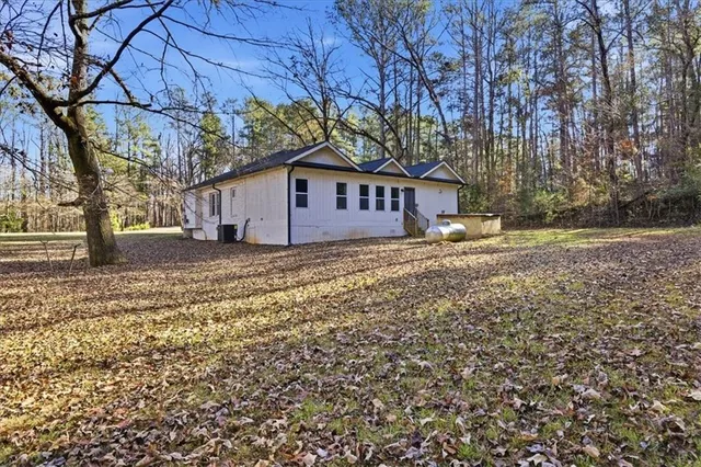 a view of a house with a yard covered in the tree