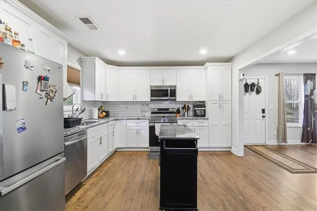 a kitchen with granite countertop stainless steel appliances and wooden cabinets