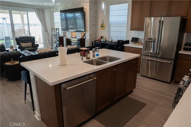 a kitchen with stainless steel appliances granite countertop a sink a counter space and a window