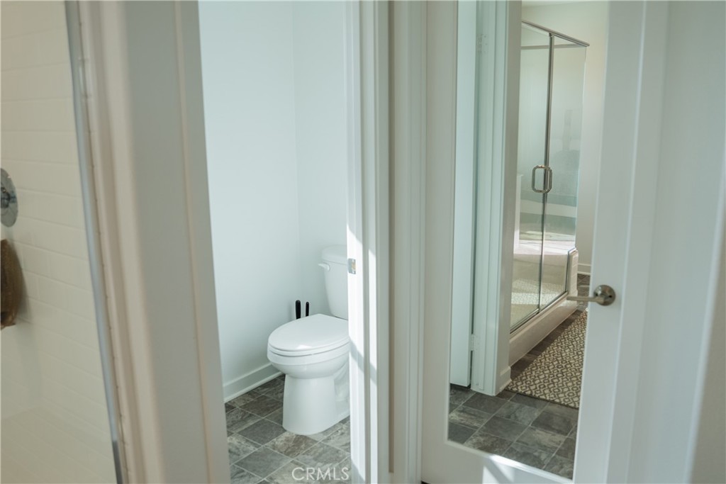 35227 Vernon Drive Beaumont, CA 92223 - Photo 30 of 49 a bathroom with a granite countertop sink a toilet and a glass door