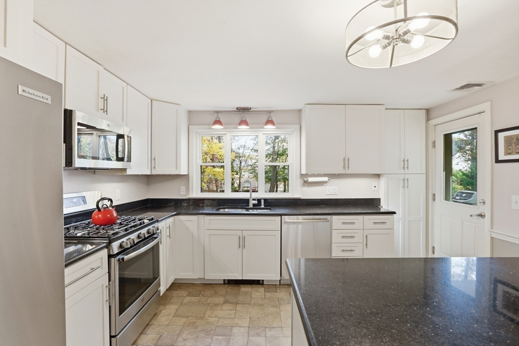 5 Carnegie Place Lexington, MA 02420 - Photo 9 of 39 a kitchen with stainless steel appliances granite countertop a stove a sink and white cabinets with wooden floor