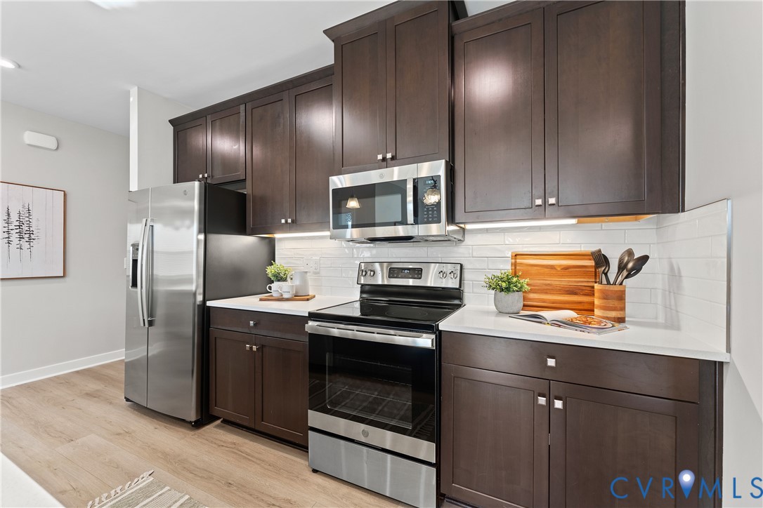 6601 Citory Way, Unit 106 Moseley, VA 23120 - Photo 13 of 39 a kitchen with stainless steel appliances granite countertop a stove a refrigerator and a stove top oven