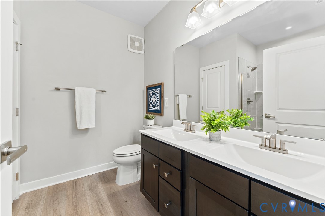 6601 Citory Way, Unit 106 Moseley, VA 23120 - Photo 18 of 39 a bathroom with a sink a toilet and mirror
