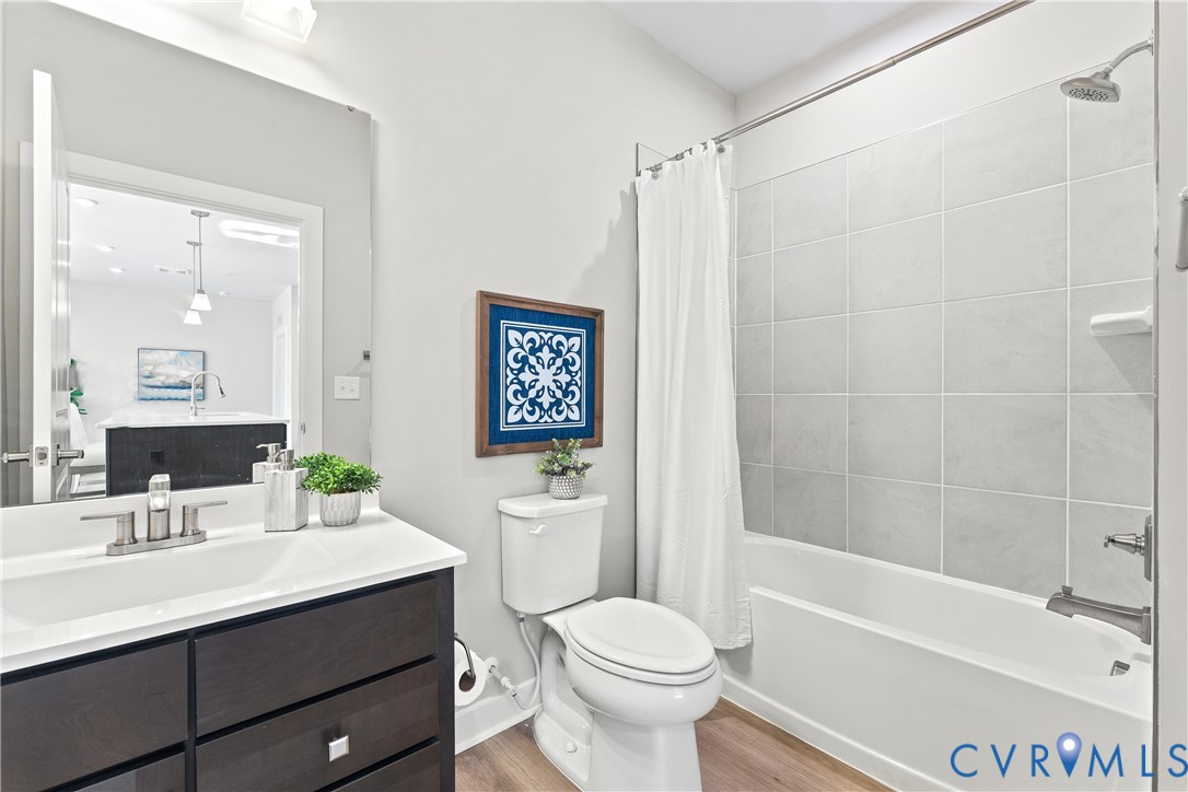 6601 Citory Way, Unit 106 Moseley, VA 23120 - Photo 22 of 39 a bathroom with a sink a toilet a mirror a bathtub and shower