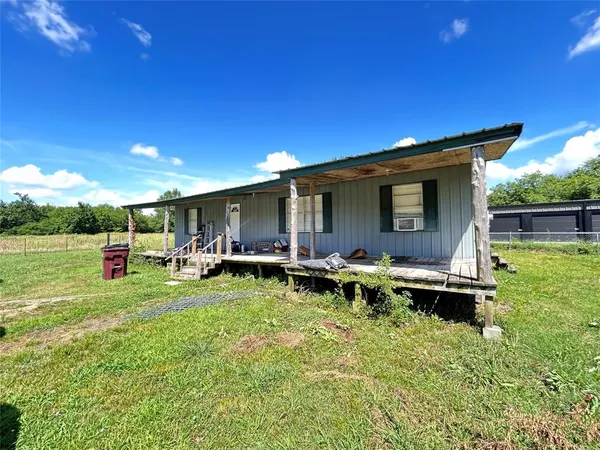 a view of a house with backyard sitting area and swimming pool